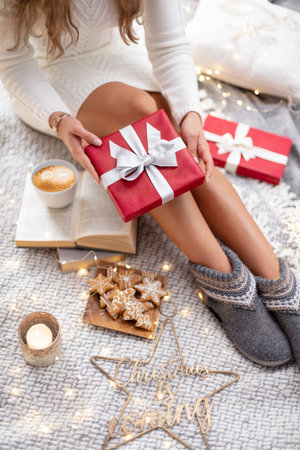 Cozy woman legs with christmas socks and gifts.の写真素材