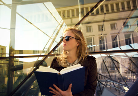 Blonde girl reading a book at sunset