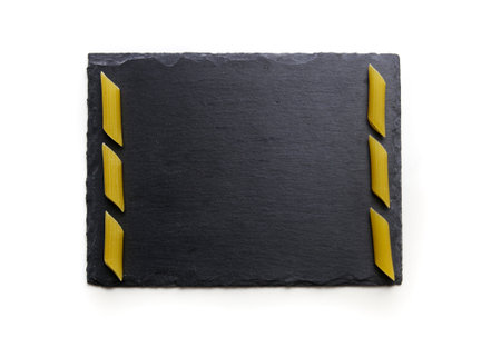 black plate with pasta on white background.の写真素材
