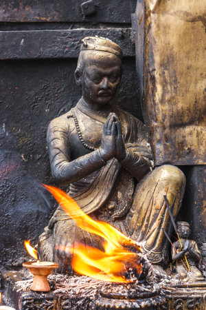 Small statue with a candle at the Swayambunath Temple, Kathmandu, Nepalの写真素材