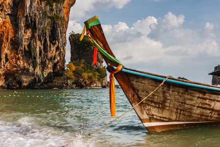Traditional thai long tail boat at sunset in Railay beach, famous travel destination, Krabi, Thailand.の写真素材