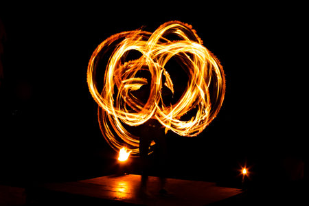 Light painting and long exposure picture of a street artist fire juggling performance. Phi Phi Island, Thailand.の写真素材