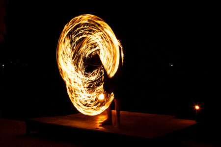 Light painting and long exposure picture of a street artist fire juggling performance. Phi Phi...