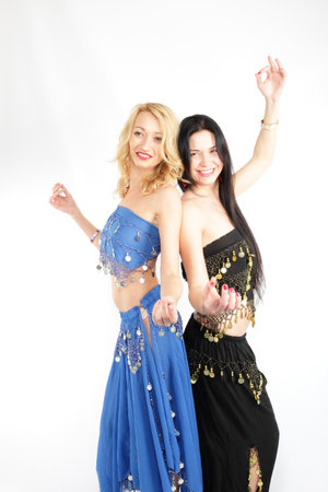 Copuple of smiling grils, blonde and brunette performing belly danceの写真素材