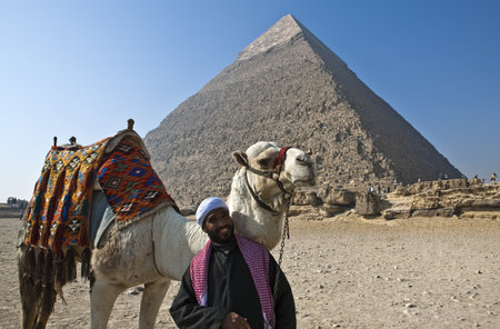 Giza, Egypt January 10, 2010: Archaeological site, a local worker with His camel in front of the Kheops pyramidのeditorial素材