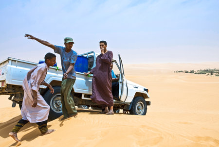 Sahara Desert, Libya - April 26, 2009: Young local man near a car in the Ubari dunes areaのeditorial素材