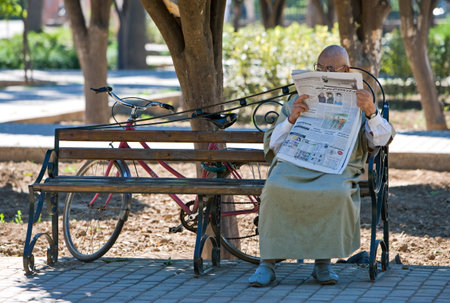 Marrakech, Morocco - March 25, 2006: A man reading the newspaper in the garden of the great Koutoubiaのeditorial素材