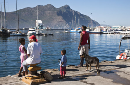 Hout Bay, South Africa - March 7, 2010: A local family with a dog in the harbourのeditorial素材