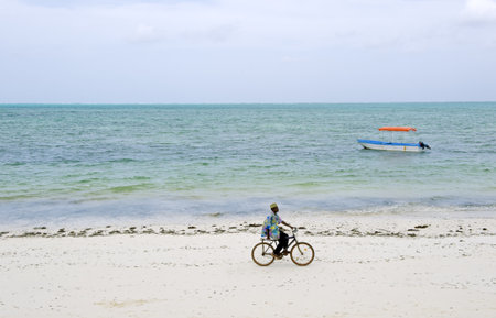 Zanzibar, Tanzania - February 28, 2008: A boy in bycicle  on the beach in the southern coastのeditorial素材