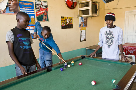 Aruscha, Tanzania - September 2, 2008: Young local people playing in a tavern of the general marketのeditorial素材