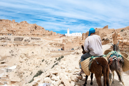 Chennini, Tunisia - April 15, 2008: A man on a donkey near the ancient berber villageのeditorial素材