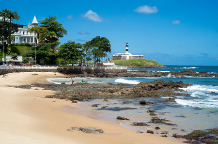 Salvador, Brazil - September 11, 2013: Barra district, people on the beach under the Forte do Farol lighthouseのeditorial素材