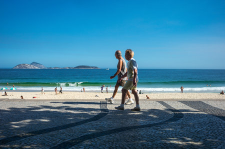 Rio De Janeiro, Brazil  - September 9, 2013: A couple walking on the Ipanema beachのeditorial素材