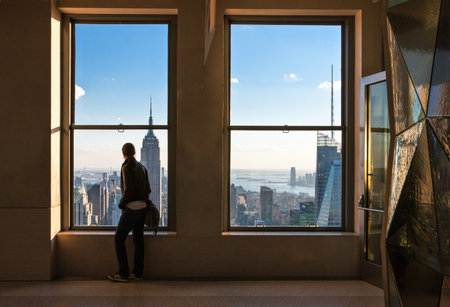 New York, U.S.A. - October 7, 20010: Manhattan, a woman in front of the windows of the Top of the Rockのeditorial素材