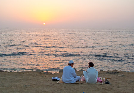 Jeddah, Saudi Arabia - November 20, 2008:  Local people on the beach of the Corniche at the sunset.のeditorial素材