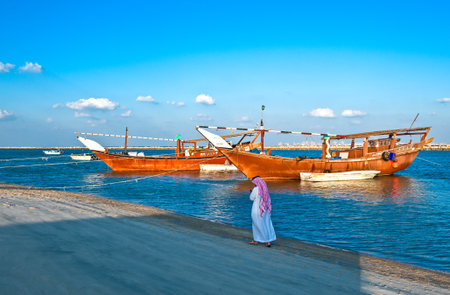 Dammam, Saudi Arabia - November 16, 2008:  A local man walking in front of the Dow boats in the...