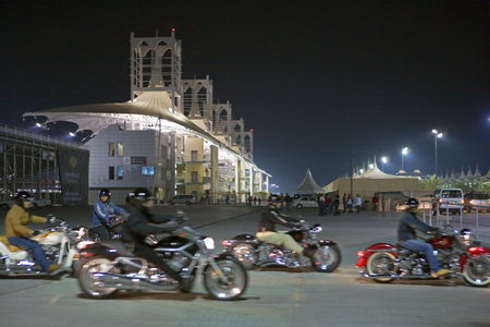 Central Desertic Area, Bahrain - December 15, 2006:  Night view of the international motorsport circuit with motorcyclist in the foreground.のeditorial素材