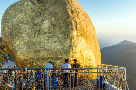 Kyaikhto,  Myanmar - January 10, 2012: Religious local people near the delicately balanced golden Stupa on the sacred Buddhist mountainのeditorial素材