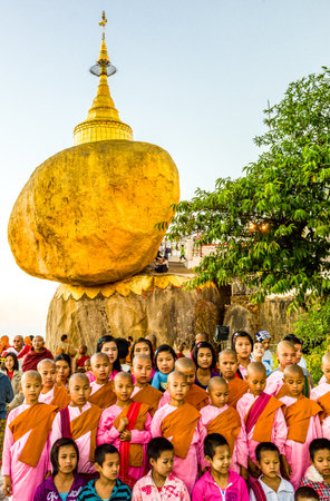 Kyaikhto,  Myanmar - January 10, 2012: Young nuns under the delicately balanced golden Stupa on the sacred Buddhist mountainのeditorial素材