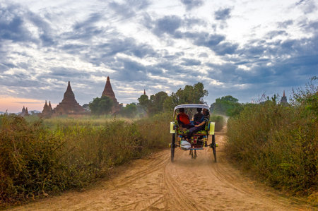 Bagan,  Myanmar - January 12, 2012:  A carriage leaving the plain with thousand of 880-year old temple ruins.のeditorial素材