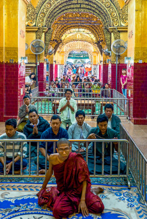 Mandalay,  Myanmar - January 13, 2012:  A monk and religious in prayer in the Mahamuni Paya temple.のeditorial素材