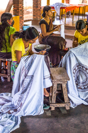 Sigirija, Sri Lanka - December 8, 2012: Young skilled craftsman in a small batik workshopのeditorial素材