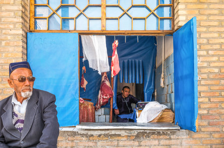 Buckara, Uzbekistan - Aprilr 16, 2014: Local people and vendors in the market on the side of the Kalon mosqueのeditorial素材