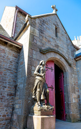 Mont St. Michel, France - May 22, 2012:  Normandy, the St Peter statue and church in the medieval village.のeditorial素材