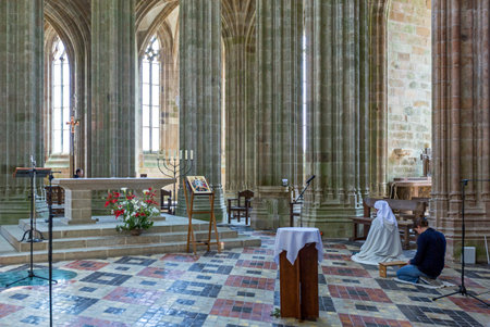 Mont St. Michel, France - May 22, 2012: Normandy, a nun in prayer in the church of the abbeyのeditorial素材