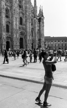 Milan, Italy - July 5, 2014: A young tourist taking pictures in  in Duomo squareのeditorial素材