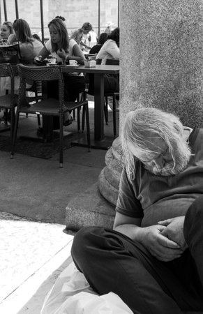 Milan, Italy - July 5, 2014: An homeless man sleeping near an open air bar in Duomo squareのeditorial素材