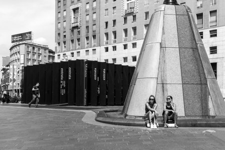 Milan, Italy - July 5, 2014: Two young ladies resting in San Babila squareのeditorial素材