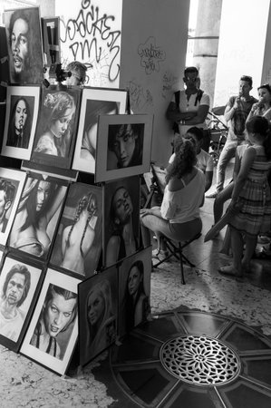 Milan, Italy - July 5, 2014: People  and paintings in Corso Vittorio Emanueleのeditorial素材