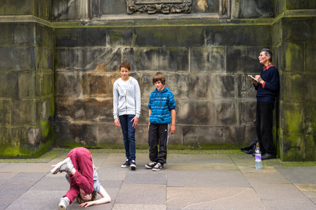 Edinburgh,  Scotland -  July 24, 2012:  Royal Mile, boys playing alongside the St Giles Cathedral.のeditorial素材