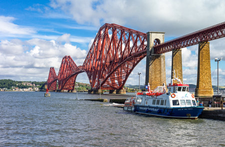 South Queenferry, Scotland - July 29,2012: Lothian area,  the Forth Rail Bridge with a tour boat mooredのeditorial素材