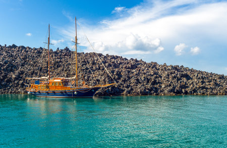 Greece, Santorini, a boat moored near the volcanic rocks of Kameni island in the Caldera sea areaの写真素材