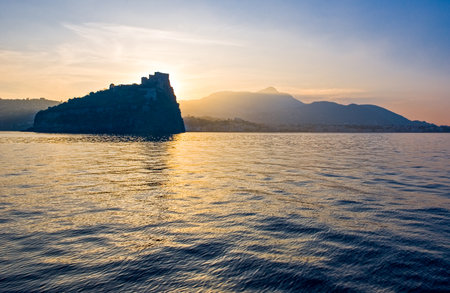 Italy, Ischia, sunset view of the coast with the Aragonese Castleの写真素材