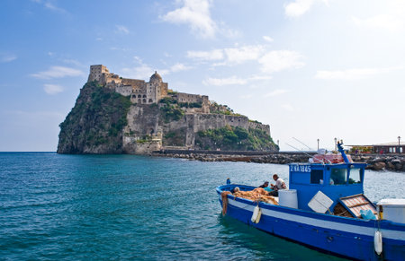 Ischia, Italy - October 17, 2008: The Aragonese Castle with a fisherman boat in the foregroundのeditorial素材
