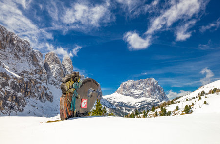 Sella Pass, Italy - April 26, 2012: Figures wearing local costumes and in the background the peacks of the Sella Group mountainsのeditorial素材
