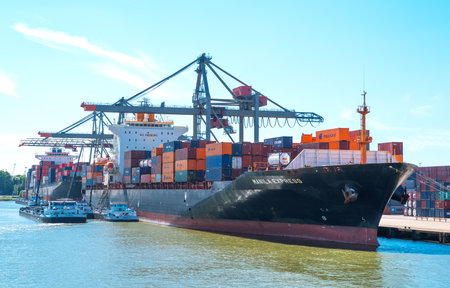 Rotterdam, The Nederlands - July 18, 2016: Goods handling equipment and cargo ships in the main commercial harbor of the cityのeditorial素材
