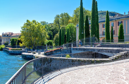 Como, Italy - August 30, 2010:  A lady walking in the lakefront with the villas in the backgroundのeditorial素材