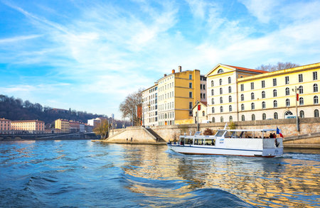 Lyon,  France - December 9, 2016:  The architectures of the old town seen from the Saone river with a boat for touristsのeditorial素材