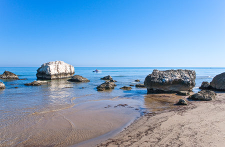 The sea in front of the village, with tourists on a small boatの写真素材