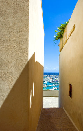 Italy, Otranto, view of the harbor from an alley of the old townの写真素材