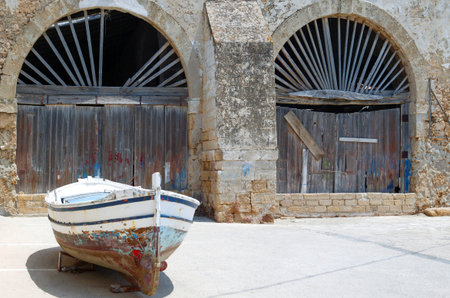 Sicily,Marzamemi, a fishermen boat in front of the old trap buildingの写真素材