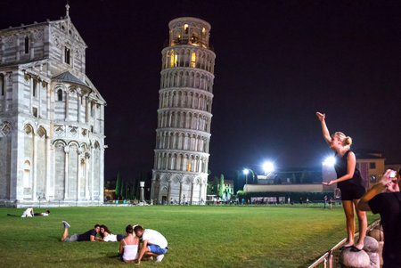 Pisa, Italy - August 22, 2012:  Dei Miracoli square, night view of people with the Cathedral and   the Leaning Tower in the backgroundのeditorial素材