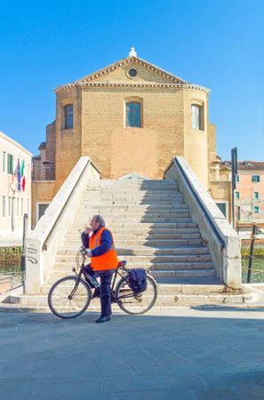 Chioggia, Italy - March 2, 2012: A man with bicycle near a bridge on Canal Vena.のeditorial素材