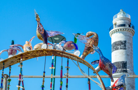 Murano, Italy - April 25, 2008:  A typical glass works with the lighthouse in the backgroundのeditorial素材
