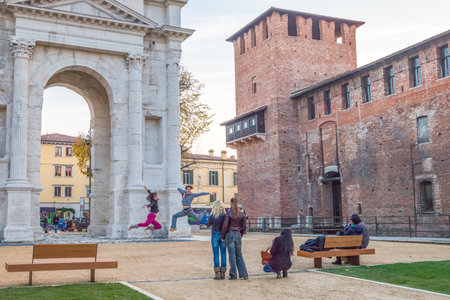 Verona, Italy - December 6, 2013: Young pople dancing in front of the Dei Gavi  Roman archのeditorial素材
