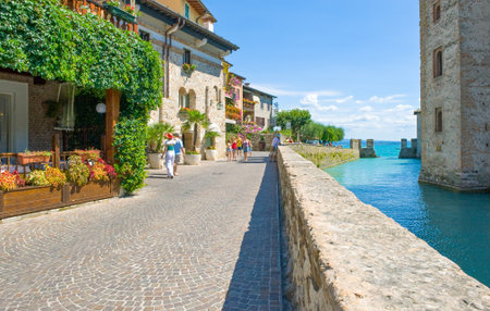 Sirmione, Italy - August 10, 2008: Garda lake, tourists in the street in front of the Rocca Scaligera castle (XIII century)のeditorial素材